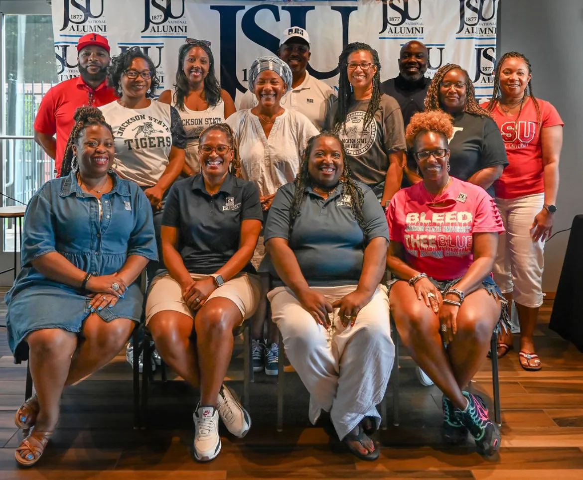 Chapter members in Jackson State gear in front of the JSU National Alumni Association backdrop