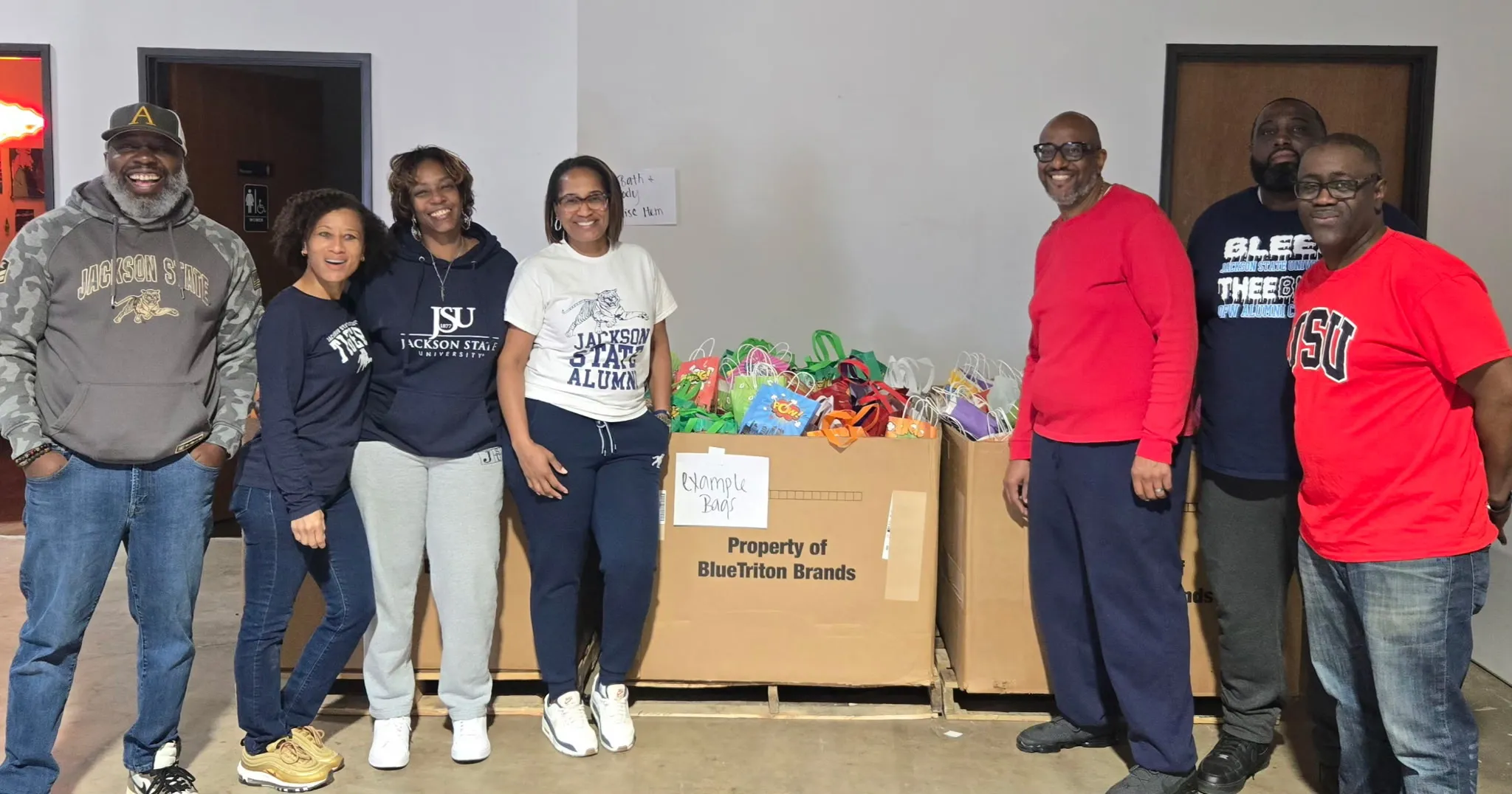 Chapter members in Jackson State gear beside boxes of filled bags at a community service day