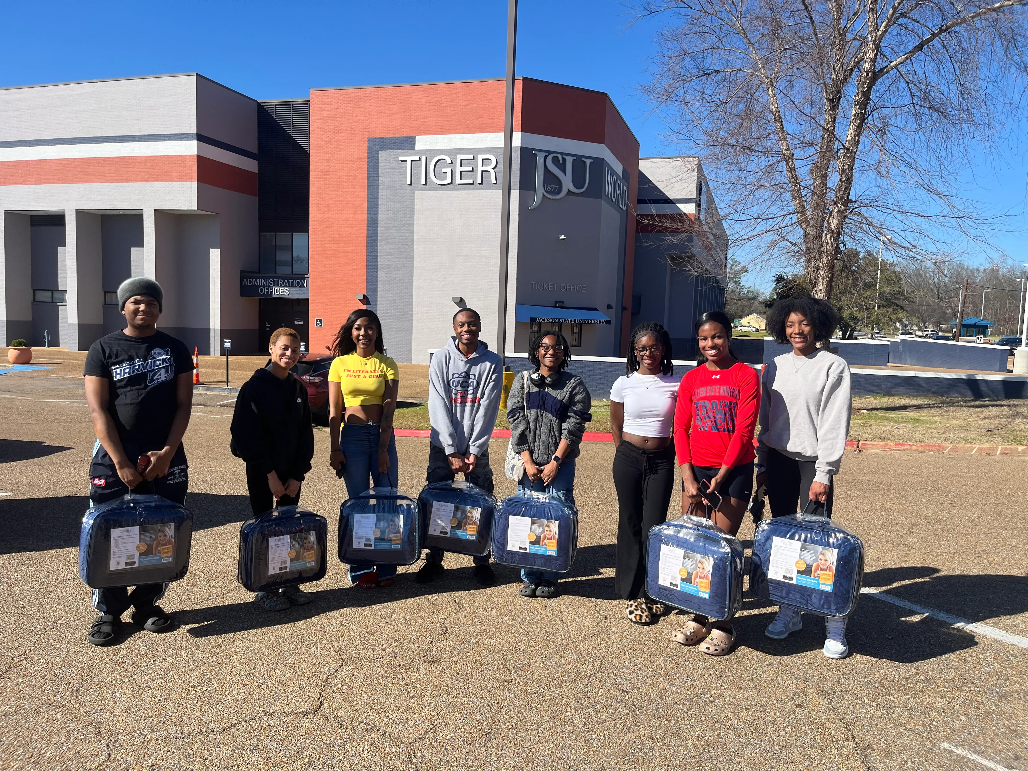 DFW students on the Jackson State campus, each holding a gift from the chapter, during a student pop-in